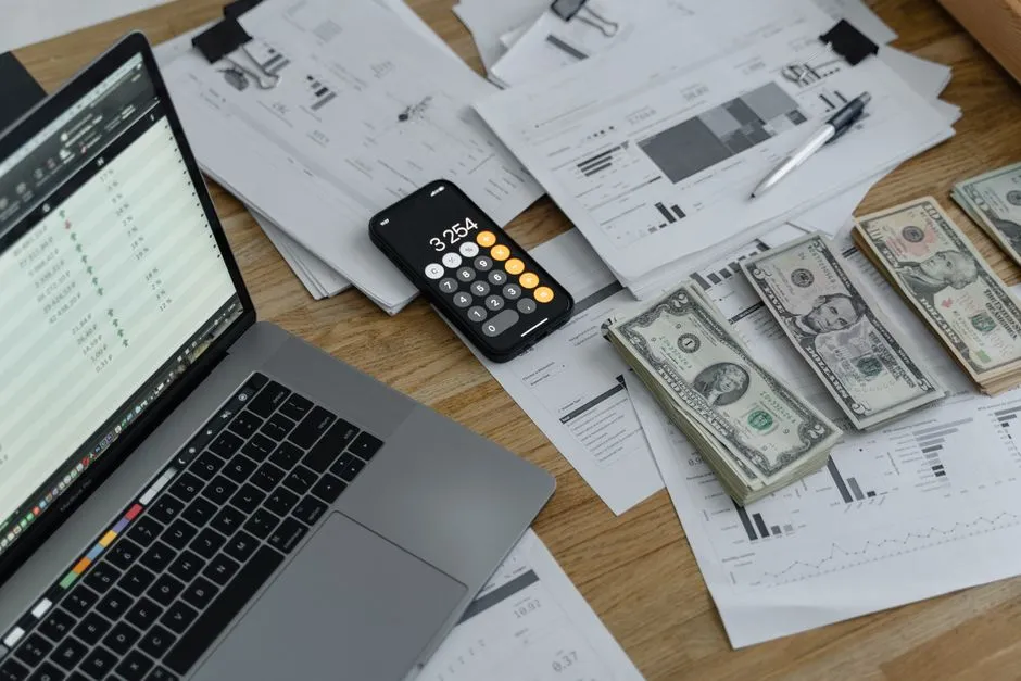 Banknotes and a calculator on a desk, representing payroll calculation