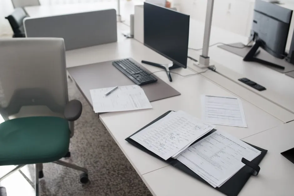 Payroll documents organized in a binder on an office desk